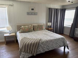 a bedroom with a bed and two windows at The Dunes in St. Augustine