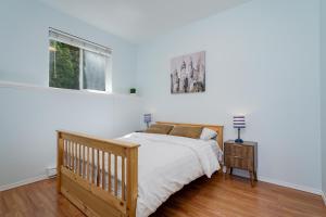 a white bedroom with a bed and a window at Ravenwood Stay With Ocean View in Victoria