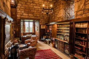 a room with a library with a table and chairs at Askham Hall in Askham