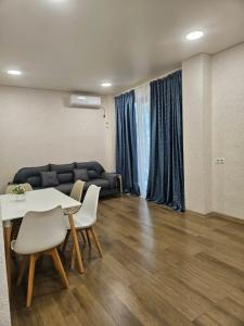 a living room with a table and chairs and a couch at Sun Estate Ureki in Ureki