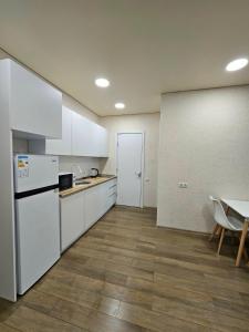 a kitchen with white cabinets and a table and a table and chairs at Sun Estate Ureki in Ureki +14 photos