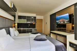 a hotel room with two beds and a flat screen tv at Villa Dvor Kornic in Budva
