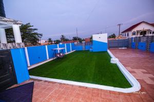 a backyard with a green lawn and blue walls at Eljay Luxury Stay in Ashalebotwe