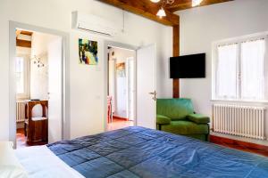 a bedroom with a bed and a green chair at laCelletta Country House in Urbino