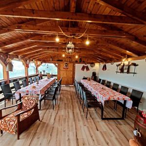 a dining room with long tables and chairs at Vatra Strabunilor in Moigrad