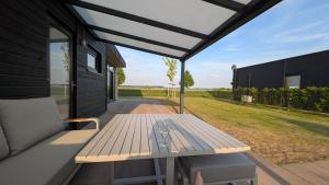 a picnic table on a porch of a house at Maison du Lac in Lathum