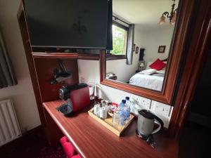 a desk with a television and a mirror in a room at Tullyeskar House - Monasterboice in Philipstown