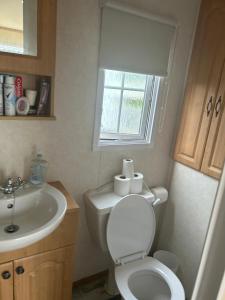 a bathroom with a toilet and a sink and a window at Nickys happy place in Greencastle +16 photos