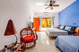 a bedroom with two beds and a chair and a fan at Villa con piscina y acceso a laguna Yalku, Akumal in Akumal