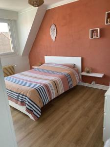 a bedroom with a large bed with orange walls at Maison cosy Dunkerque in Dunkerque