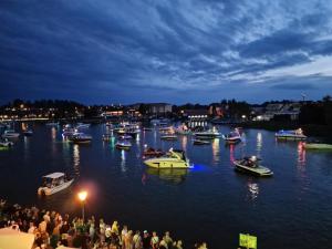 a group of boats in the water at night at Pokoje Śpij-tu z jacuzzi in Mikołajki
