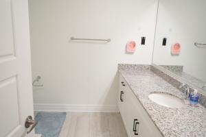 a white bathroom with a sink and a mirror at Charming Oakville Getaway in Oakville