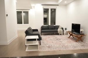 a living room with a couch and a tv at Charming Oakville Getaway in Oakville