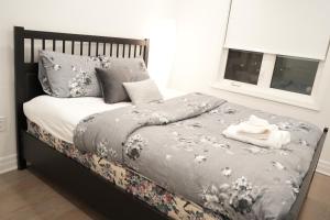 a bedroom with a bed with a gray blanket and pillows at Charming Oakville Getaway in Oakville