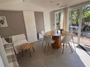 a living room with a table and a couch at Chalet Masion Meerwijck 6 aan het Zuidlaardermeer in Kropswolde