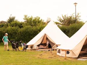 a man standing next to a tent with two dogs at Aparra Surfcamp Auberge Saint-Jean-de-Luz in Saint-Jean-de-Luz