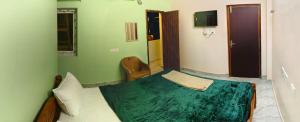 a bedroom with a bed and a chair in it at Ronazio Beach View Residency in Auroville +36 photos
