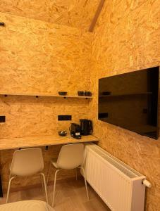 a room with two chairs and a table and a television at Petite maison village fruitier in Gingelom