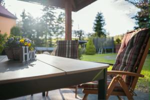 a table and chairs on a patio with an umbrella at Trzy Wzgórza Huwniki in Huwniki