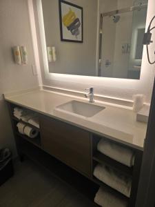 a bathroom with a sink and a large mirror at Rodeway Inn in Portage