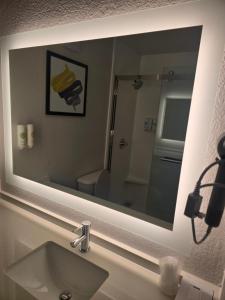 a mirror above a sink in a bathroom at Rodeway Inn in Portage