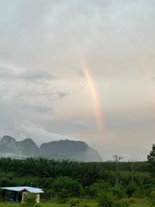 a rainbow in the sky with mountains in the background at Boonfarm&homestay in Ban Nop Hak +2 photos