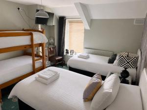 a bedroom with two bunk beds and a room with two beds at Holland Hotel in Llanfachraeth