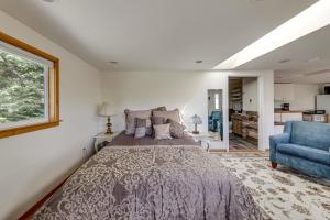 a bedroom with a bed and a blue chair at Walkable, Dog Friendly! Friday Harbor Stay w/ Deck in Friday Harbor