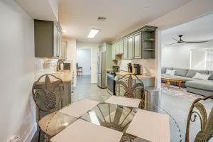 a kitchen and living room with a glass table and chairs at Deck + Pool Table! Walk to Dtwn Jensen Beach in Jensen Beach