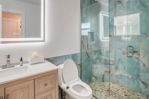 a bathroom with a toilet and a glass shower at Deck + Pool Table! Walk to Dtwn Jensen Beach in Jensen Beach +17 photos
