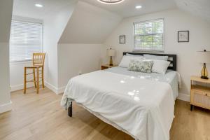 a bedroom with a large white bed and a chair at Deck + Pool Table! Walk to Dtwn Jensen Beach in Jensen Beach