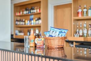 a counter with bottles of beer and a basket of chips at Marine Court Three Bedroom Second-floor Apartment 32 in Littlehampton