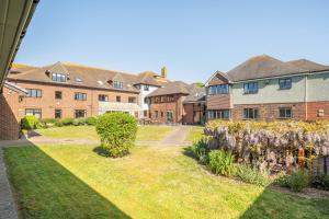 a row of brick houses in a yard with flowers at Marine Court Three Bedroom Second-floor Apartment 32 in Littlehampton