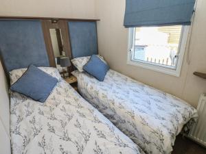 a bedroom with two beds and a window at Plot 42 in Carlisle