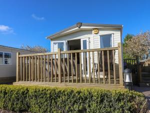a small white house with a wooden fence at Plot 42 in Carlisle