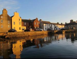 a group of houses next to a body of water at Bellevue Inn in Saint Margarets Hope