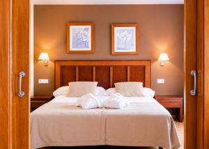 a bedroom with a bed with towels on it at ARVA Santiago León in León