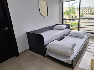 two beds in a room with a window at Nice and Modern Apartment, Parking in SamborondÃ³n +54 photos