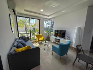 a living room with a couch and chairs and a tv at Nice and Modern Apartment, Parking in SamborondÃ³n
