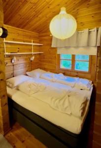 a bedroom with a bed in a wooden cabin at Villa Safari in Perniö