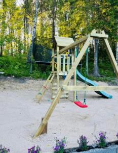 a wooden playground with a slide in a park at Villa Safari in Perniö