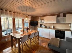 a kitchen with a table and chairs in a room at Villa Safari in Perniö