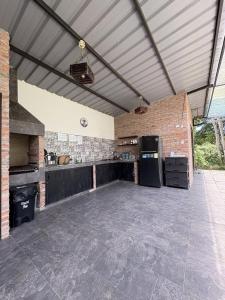 a large patio with a kitchen and a brick wall at Rio Olón ecolodge in Olón