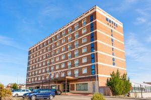 a hotel building with cars parked in a parking lot at ARVA Santiago León in León