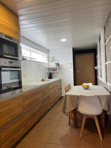 a kitchen with a table and a table and a kitchen with a counter at Casa Xoubiña in Mos