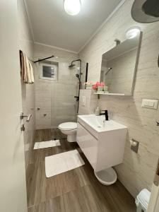 a bathroom with a white sink and a toilet at Apartmani Frane in Neum