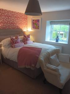 a bedroom with a large bed and a chair at Lucker Mill House in Lucker