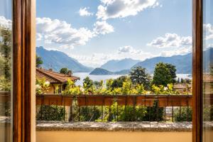 a window with a view of a lake and mountains at Villa Le Rose, Menaggio in Menaggio