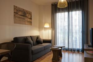a living room with a couch and a large window at MH Apartments Gracia in Barcelona