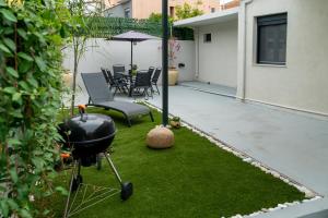 a backyard with a grill and a table and chairs at Latitude 37 Luxe in Kalamata